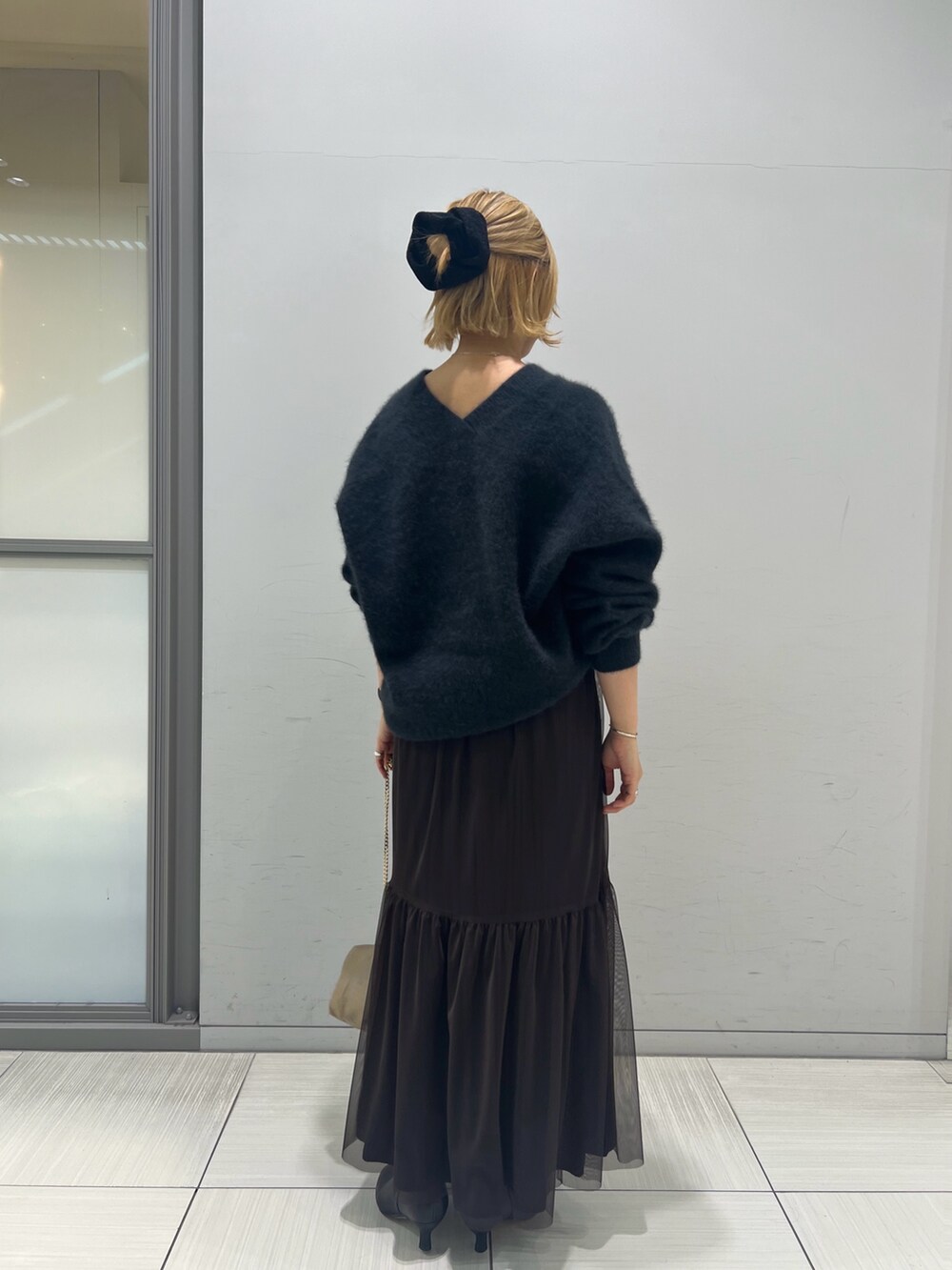 グレー系のニット/セーター、ブラウン系のスカート、ブラック系のブーツを着用したレディースの秋コーディネートの5枚目の写真