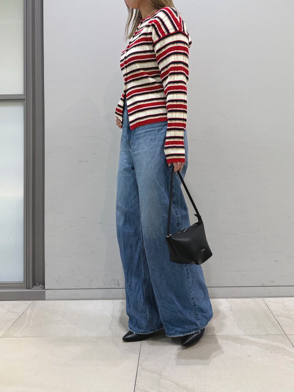その他のニット/セーター、ブルー系のデニムパンツ、ブラック系のショルダーバッグを着用したレディースの冬コーディネートの4枚目の写真