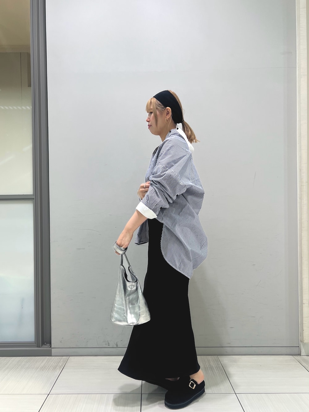 ブルー系のシャツ/ブラウス、ブラック系のスカート、ブラック系のトートバッグを着用したレディースの夏コーディネートの5枚目の写真
