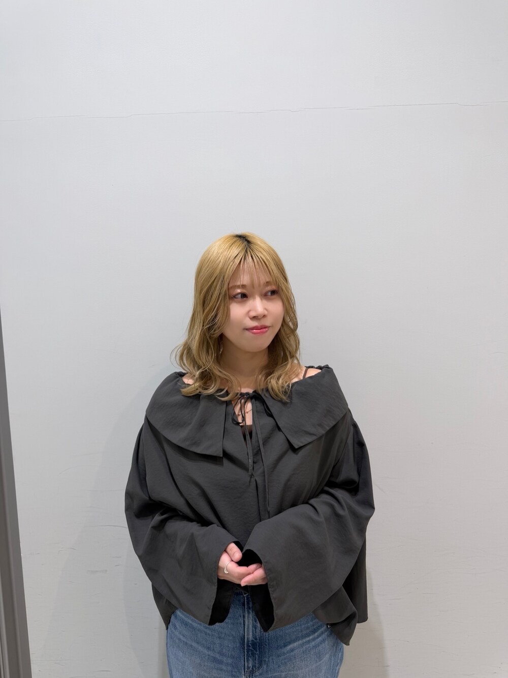 ブルー系のデニムパンツ、オレンジ系のショルダーバッグ、グレー系のシャツ/ブラウスを着用したレディースの春コーディネートの3枚目の写真
