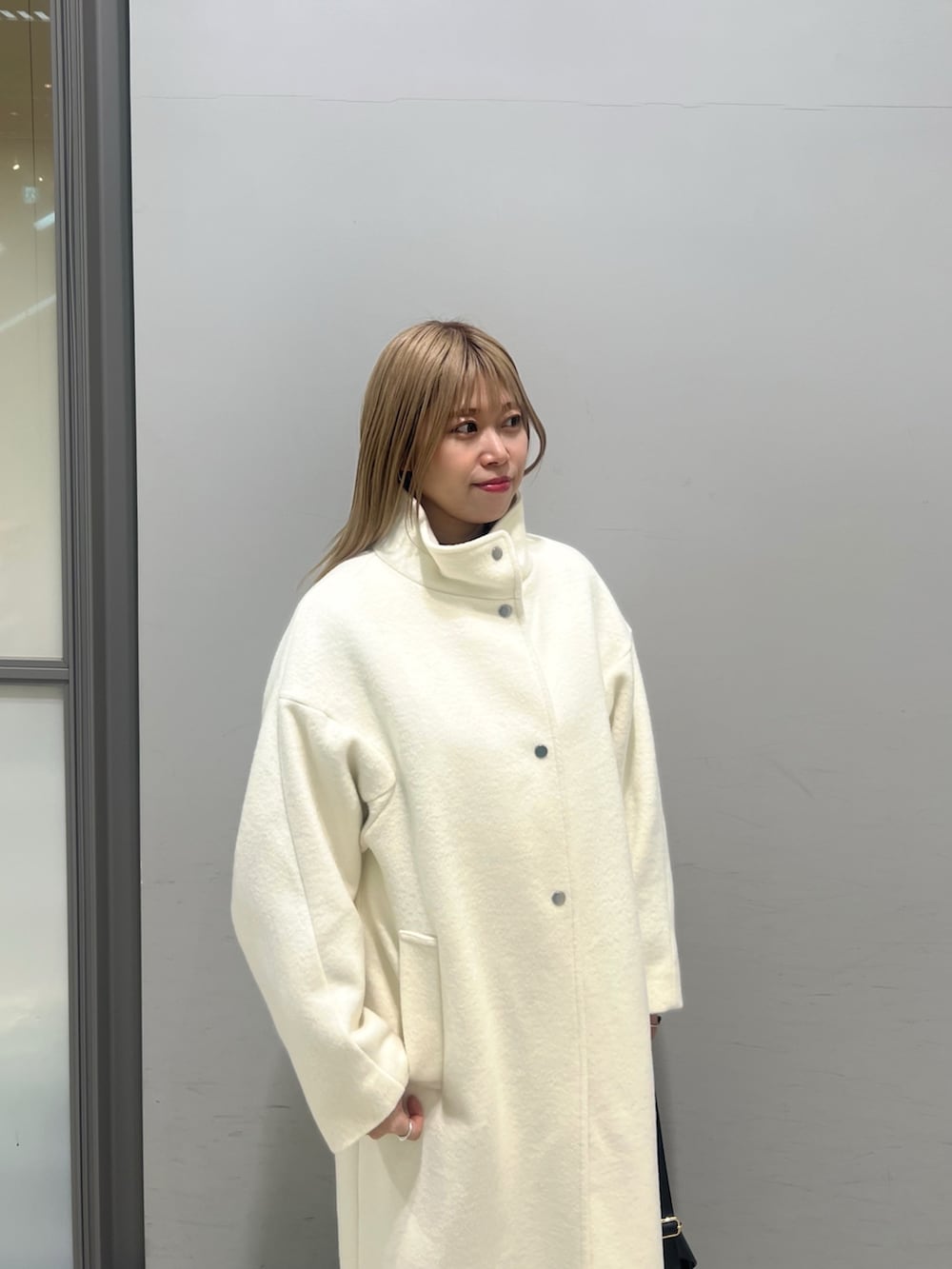 ブラック系のショルダーバッグ、ブラック系のブーツ、ホワイト系のその他アウターを着用したレディースの冬コーディネートの10枚目の写真