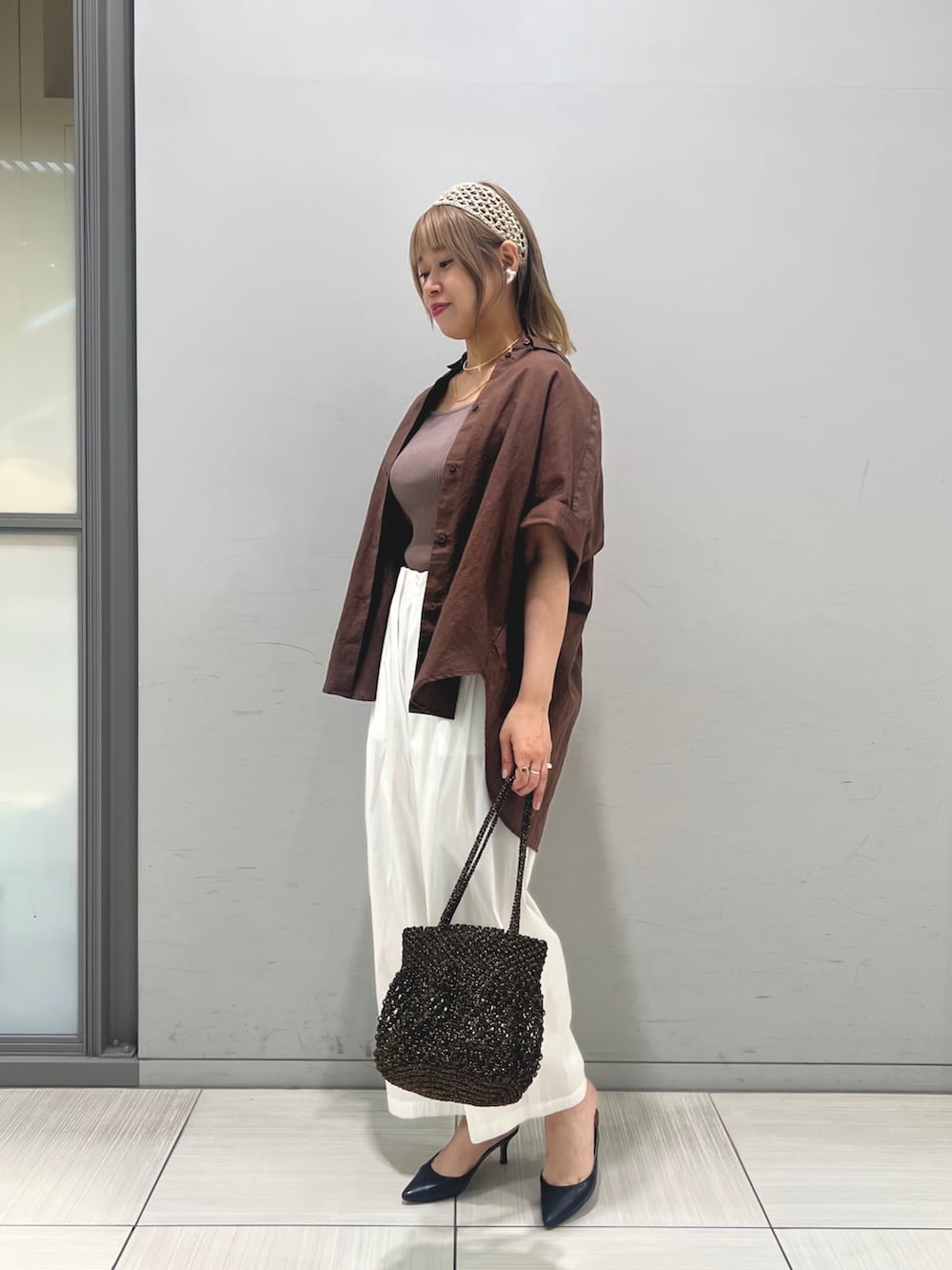 ブラック系のタンクトップ、ホワイト系のその他パンツ、ブラック系のショルダーバッグを着用したレディースの夏コーディネートの2枚目の写真