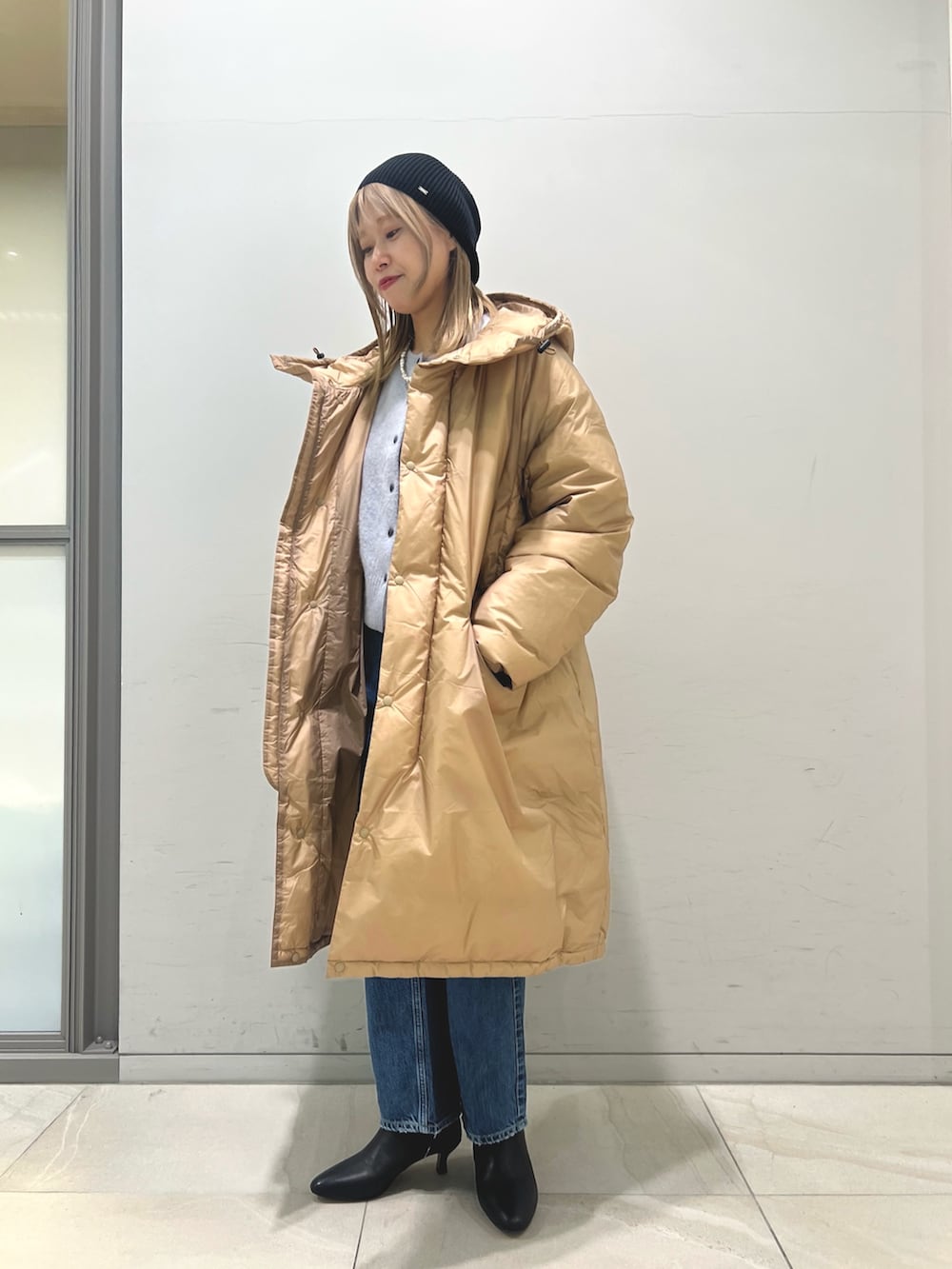 ブラウン系のダウンジャケット/コート、ブルー系のカーディガン/ボレロ、ブルー系のデニムパンツを着用したレディースの冬コーディネートの3枚目の写真