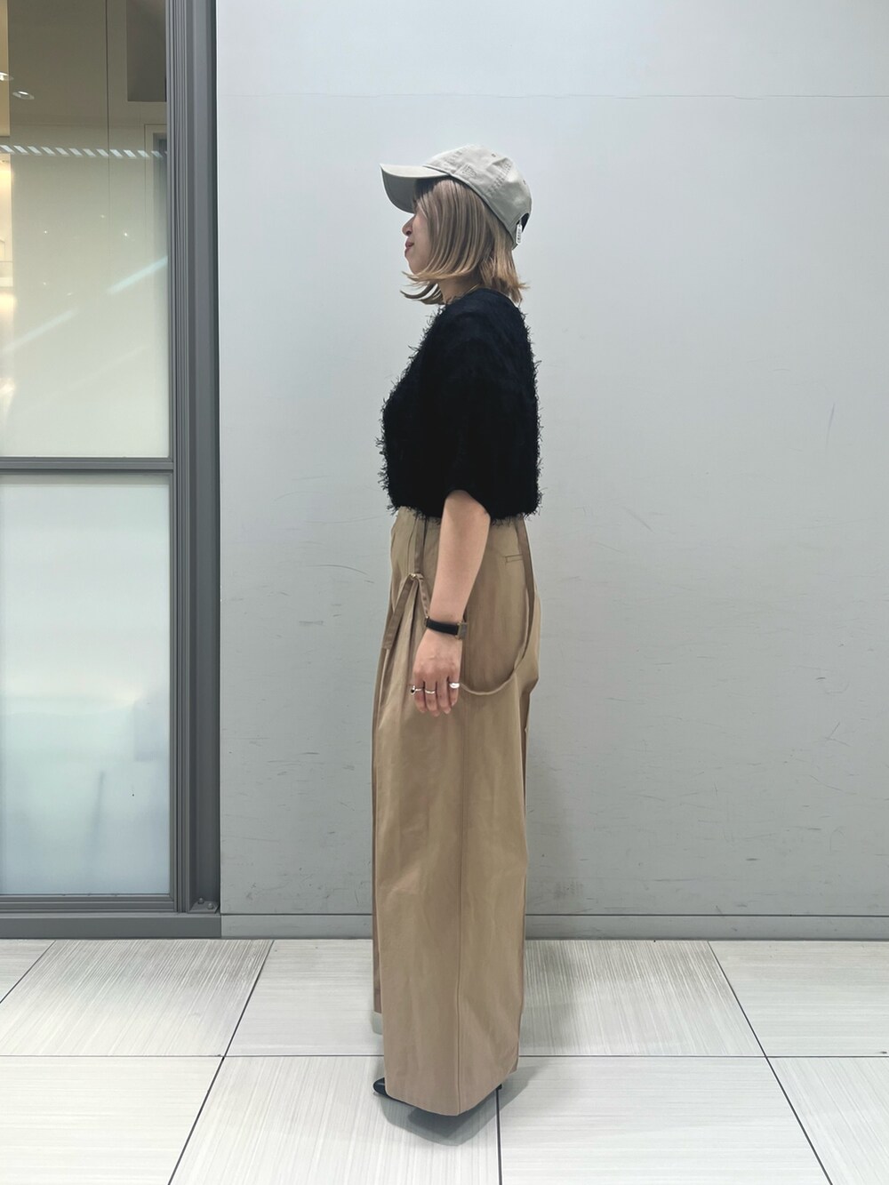 ブラック系のニット/セーター、ベージュ系のその他パンツ、ブラック系のトートバッグを着用したレディースの春コーディネートの6枚目の写真