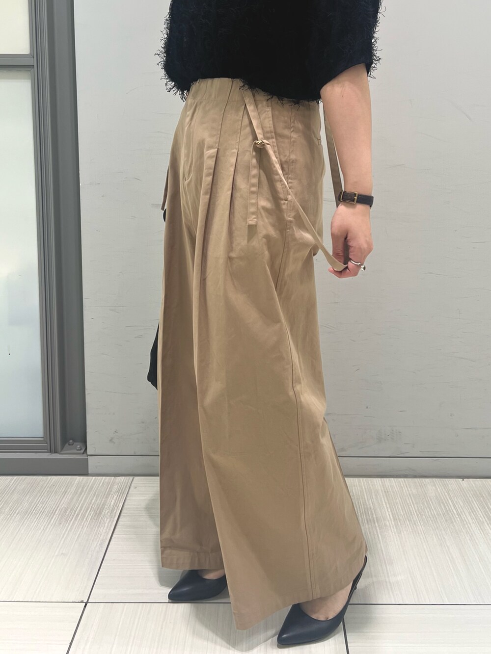 ブラック系のニット/セーター、ベージュ系のその他パンツ、ブラック系のトートバッグを着用したレディースの春コーディネートの5枚目の写真