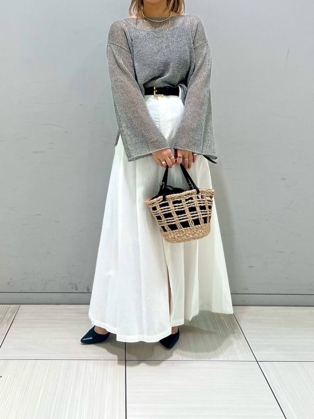 ブラック系のパンプス、グレー系のニット/セーター、ブラウン系のスカートを着用したレディースの春コーディネートの2枚目の写真