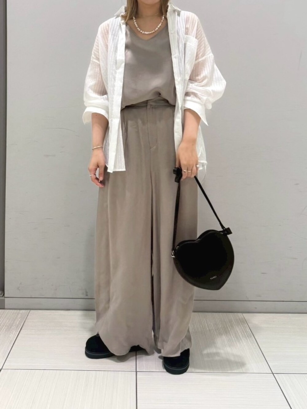 ブラック系のサンダル、ホワイト系のシャツ/ブラウス、ブラック系のショルダーバッグを着用したレディースの夏コーディネートの5枚目の写真