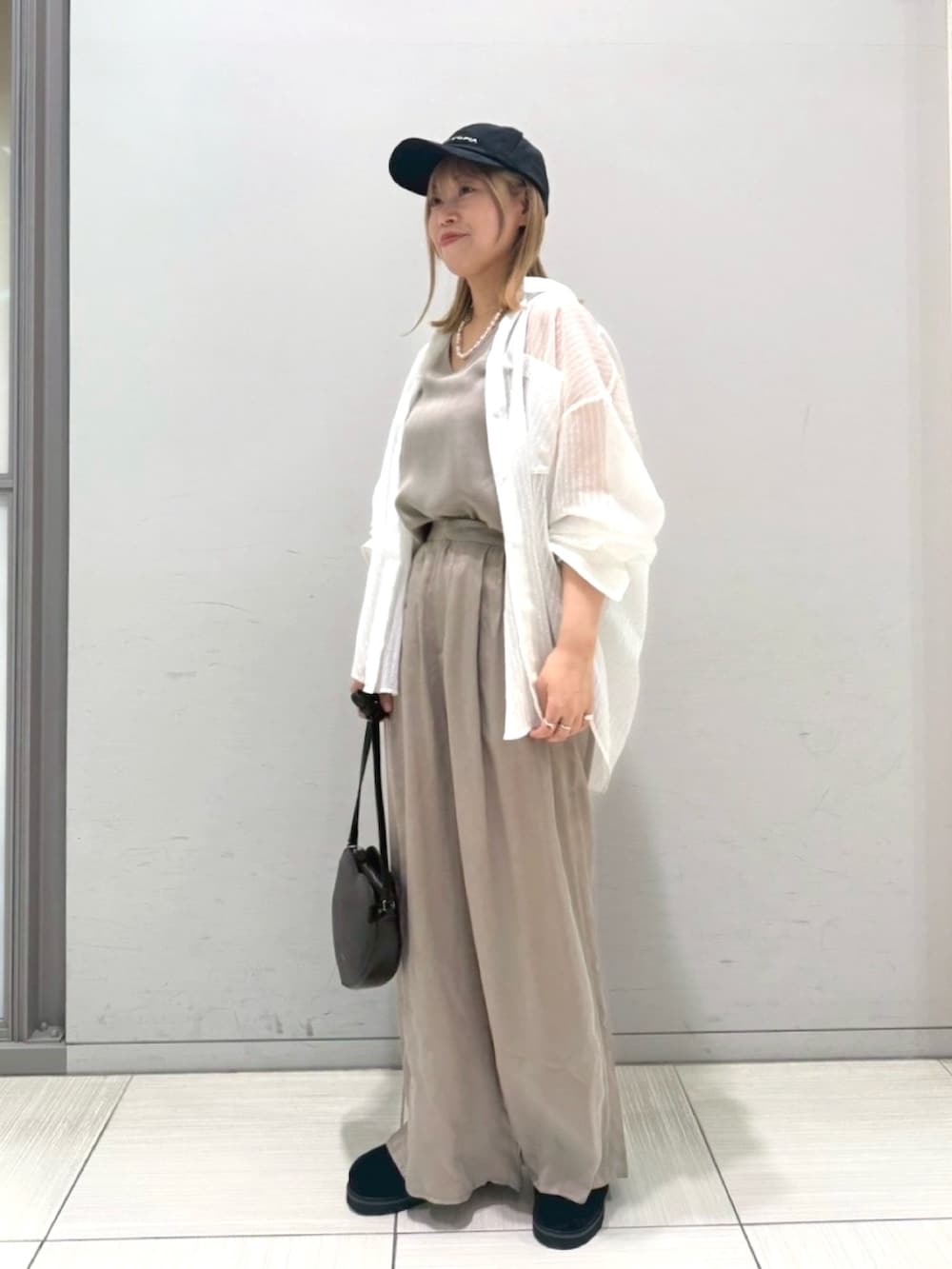 ブラック系のサンダル、ホワイト系のシャツ/ブラウス、ブラック系のショルダーバッグを着用したレディースの夏コーディネートの8枚目の写真