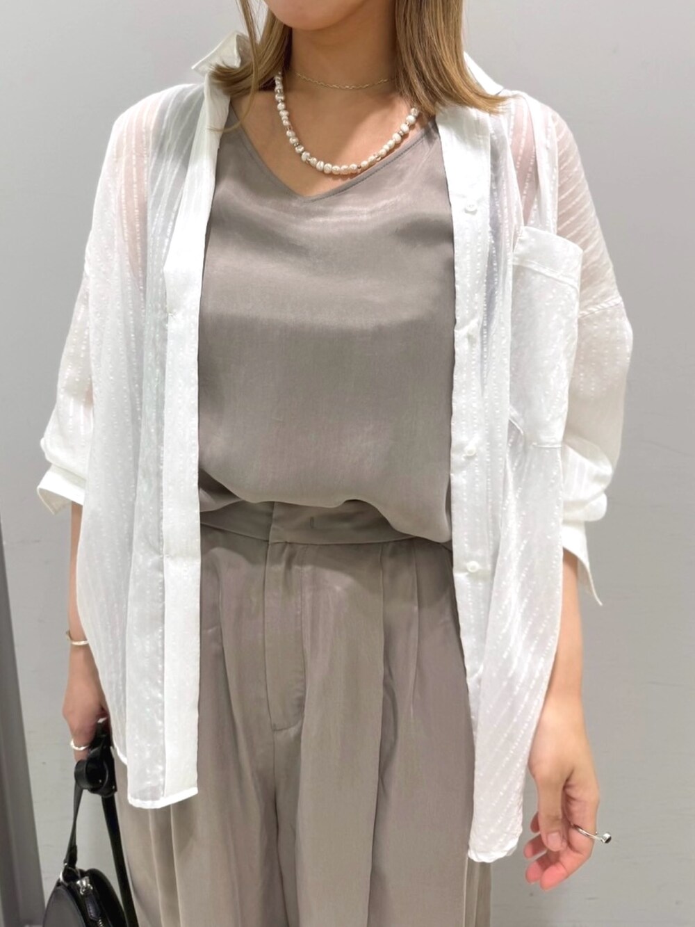 ブラック系のサンダル、ホワイト系のシャツ/ブラウス、ブラック系のショルダーバッグを着用したレディースの夏コーディネートの6枚目の写真