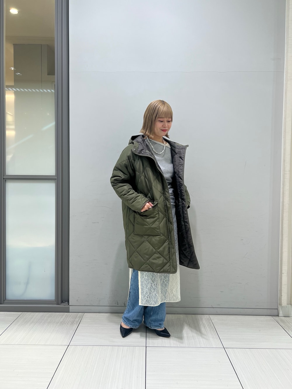 ホワイト系のワンピース、グレー系のTシャツ/カットソー、ブルー系のデニムパンツを着用したレディースの冬コーディネートの3枚目の写真