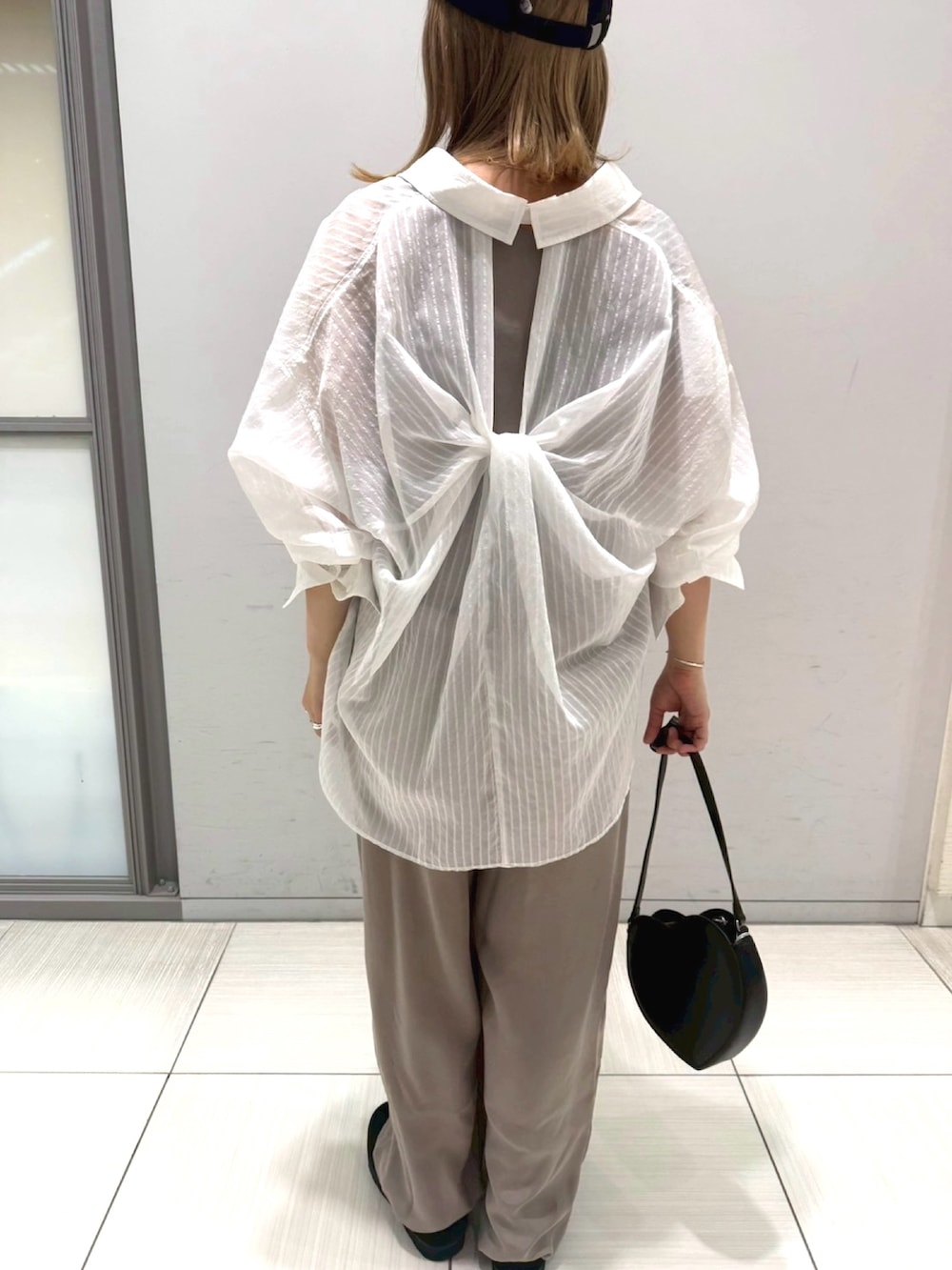 ブラック系のサンダル、ホワイト系のシャツ/ブラウス、ブラック系のショルダーバッグを着用したレディースの夏コーディネートの7枚目の写真