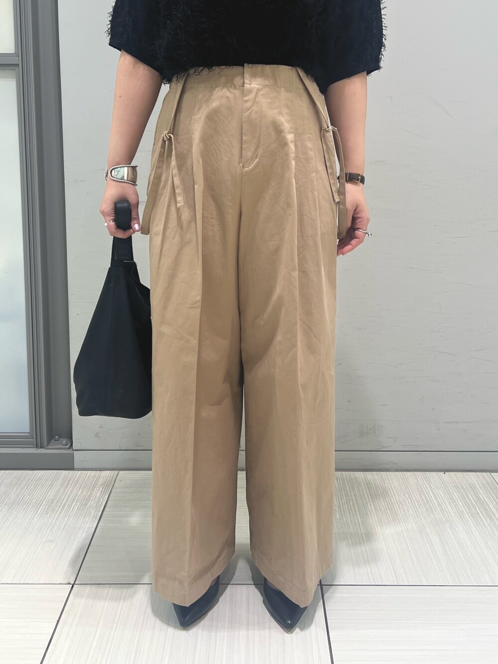 ブラック系のニット/セーター、ベージュ系のその他パンツ、ブラック系のトートバッグを着用したレディースの春コーディネートの4枚目の写真