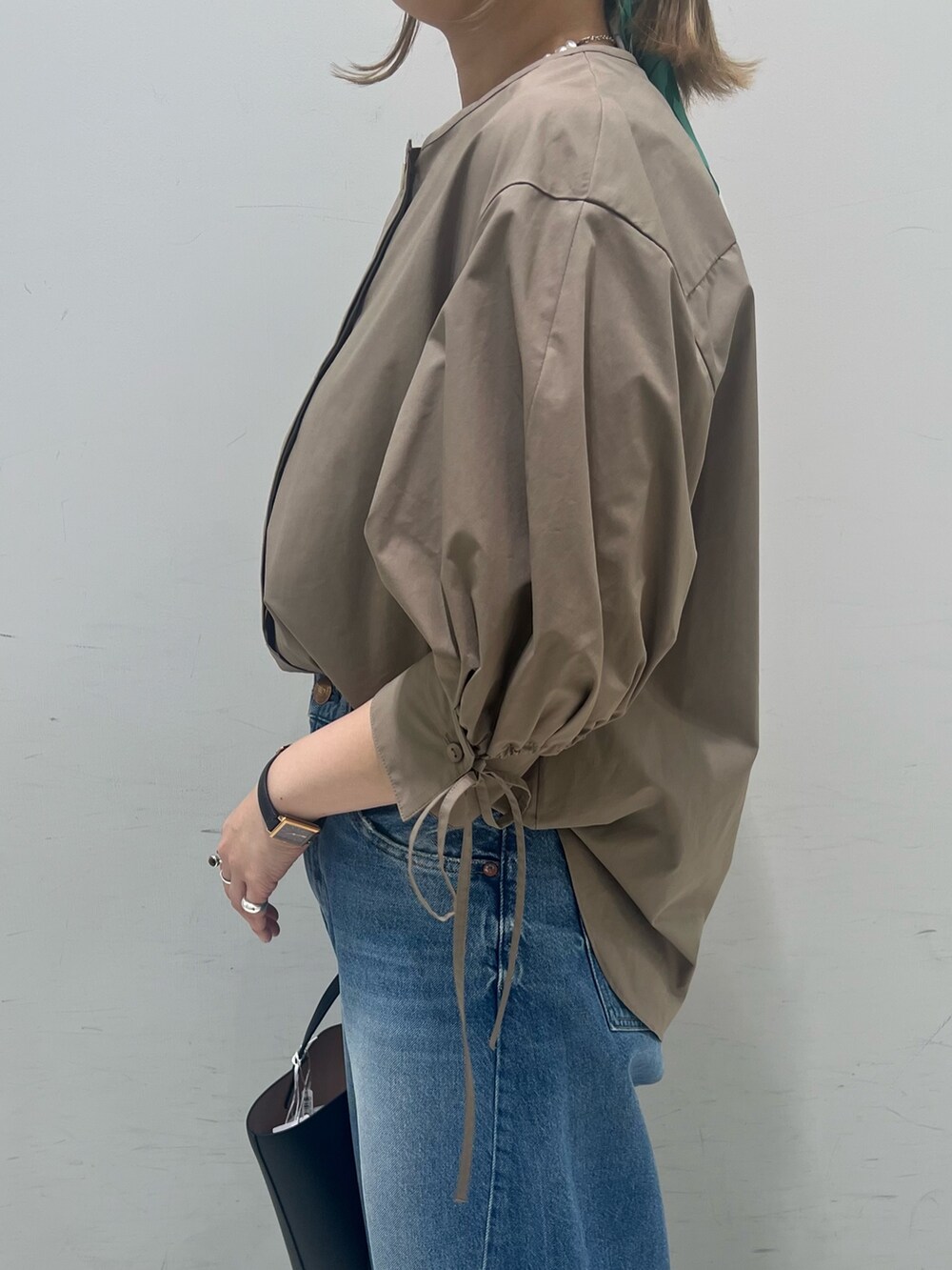 ブラウン系のシャツ/ブラウス、ブルー系のデニムパンツ、ブラック系のハンドバッグを着用したレディースの春コーディネートの6枚目の写真