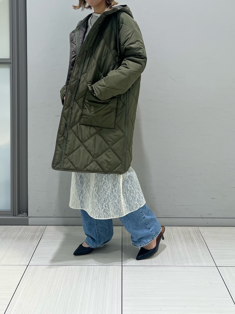 ホワイト系のワンピース、グレー系のTシャツ/カットソー、ブルー系のデニムパンツを着用したレディースの冬コーディネートの7枚目の写真