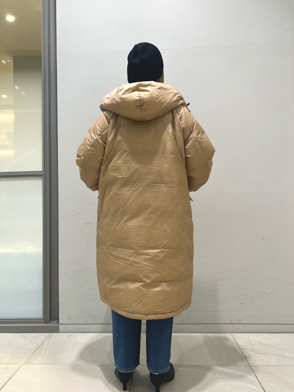 ブラウン系のダウンジャケット/コート、ブルー系のカーディガン/ボレロ、ブルー系のデニムパンツを着用したレディースの冬コーディネートの4枚目の写真