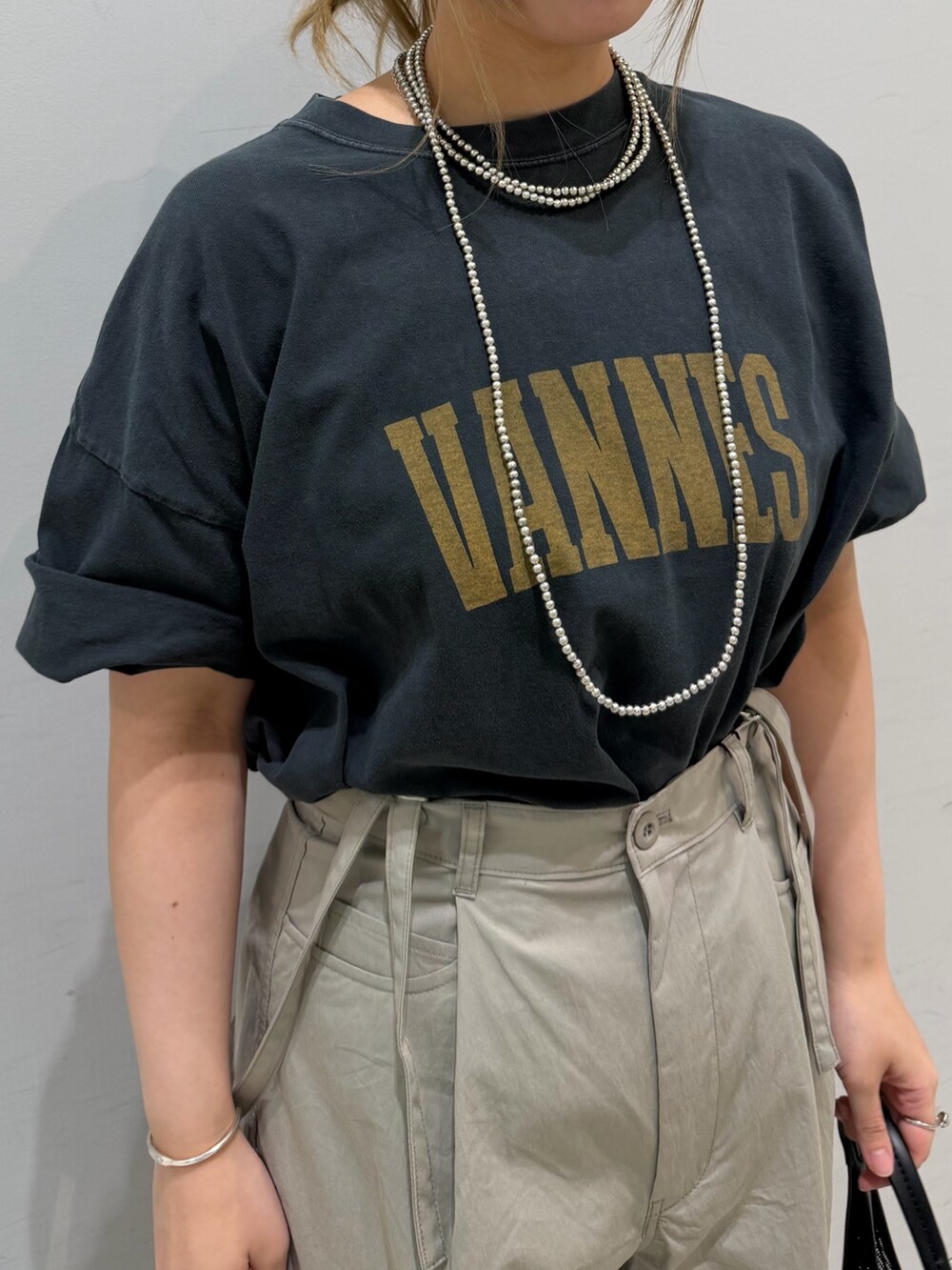 ベージュ系のその他パンツ、ブラック系のTシャツ/カットソー、ブラック系のトートバッグを着用したレディースの春コーディネートの9枚目の写真