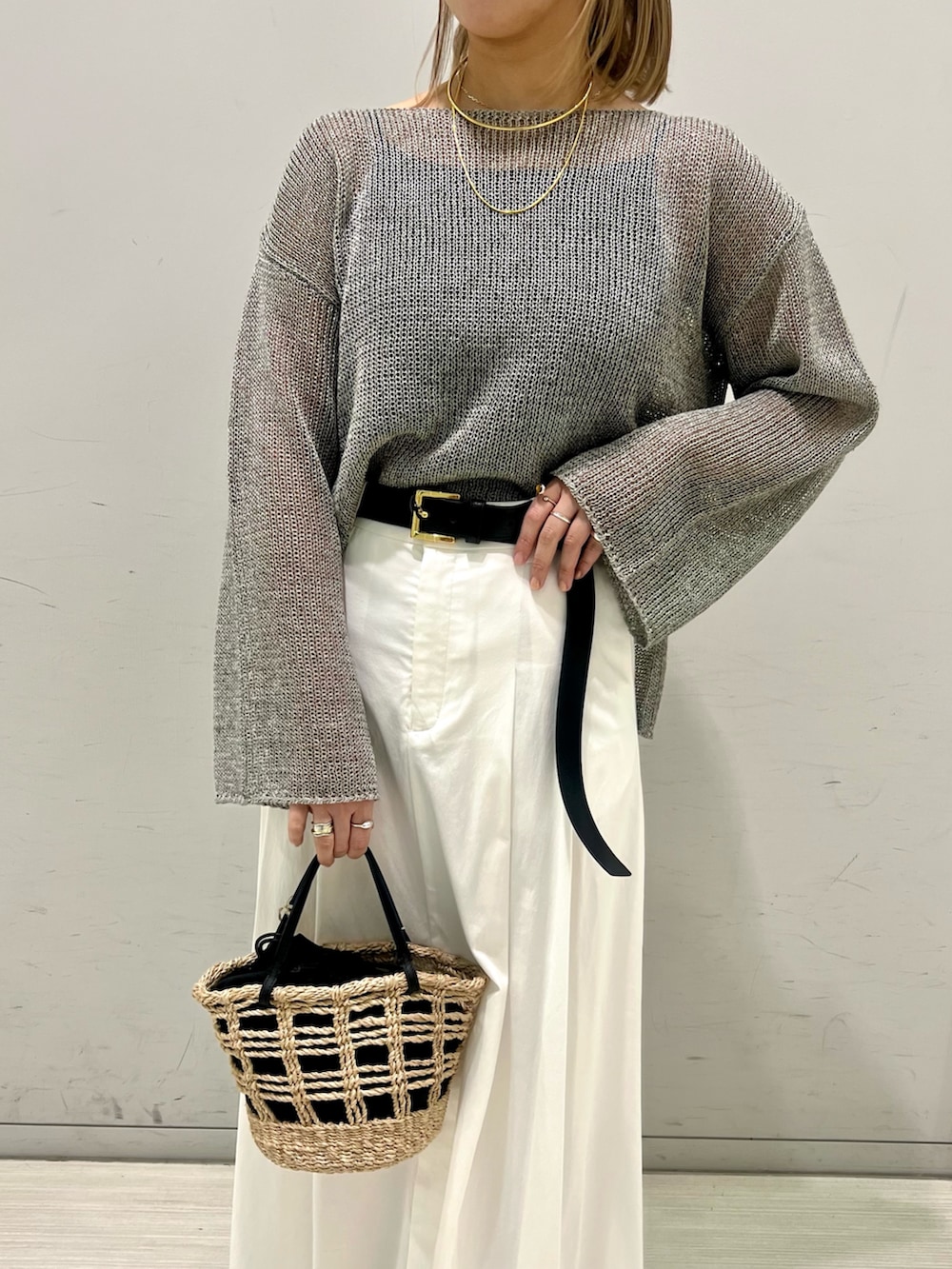 ブラック系のパンプス、グレー系のニット/セーター、ブラウン系のスカートを着用したレディースの春コーディネートの3枚目の写真