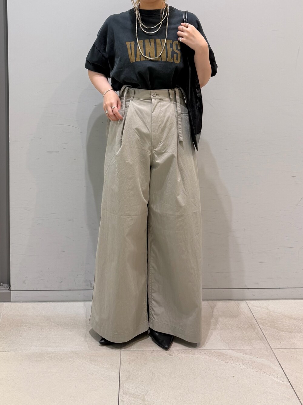 ベージュ系のその他パンツ、ブラック系のTシャツ/カットソー、ブラック系のトートバッグを着用したレディースの春コーディネートの10枚目の写真