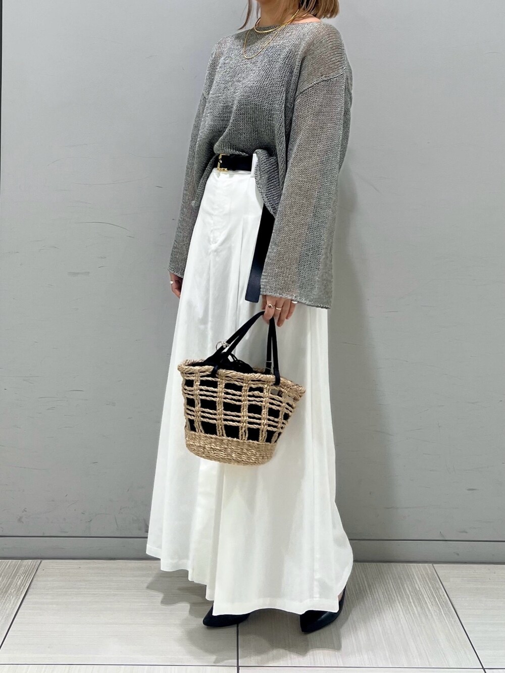 ブラック系のパンプス、グレー系のニット/セーター、ブラウン系のスカートを着用したレディースの春コーディネートの5枚目の写真