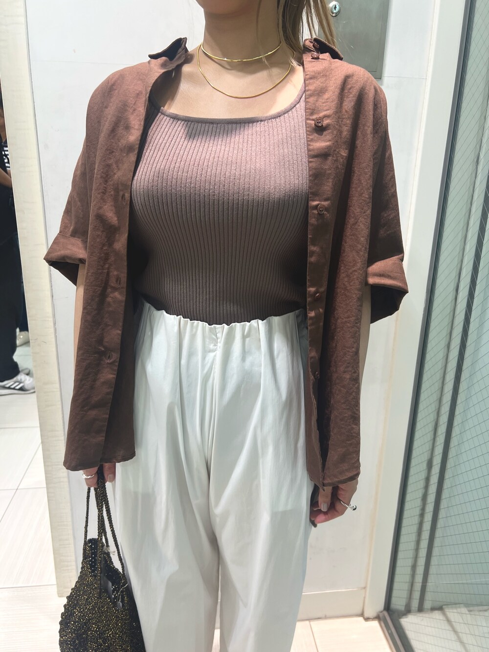 ブラック系のタンクトップ、ホワイト系のその他パンツ、ブラック系のショルダーバッグを着用したレディースの夏コーディネートの5枚目の写真