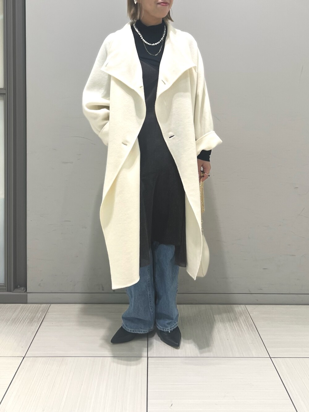 ホワイト系のその他アウター、ブラウン系のワンピース、ホワイト系のショルダーバッグを着用したレディースの冬コーディネートの2枚目の写真