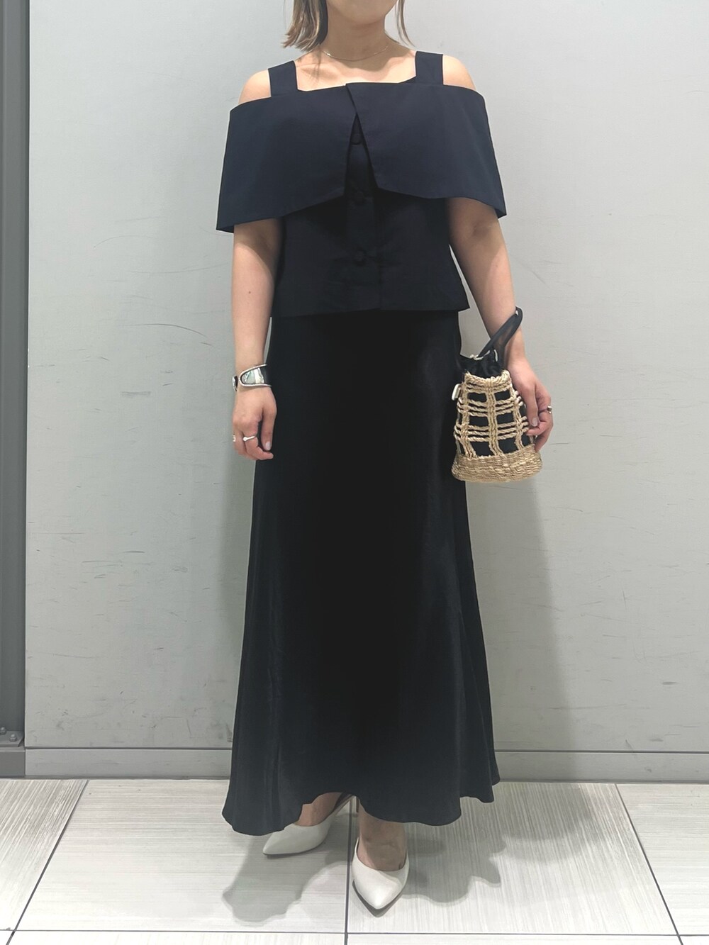 ベージュ系のかごバッグ、ブラック系のシャツ/ブラウス、ブラック系のスカートを着用したレディースの春コーディネートの3枚目の写真