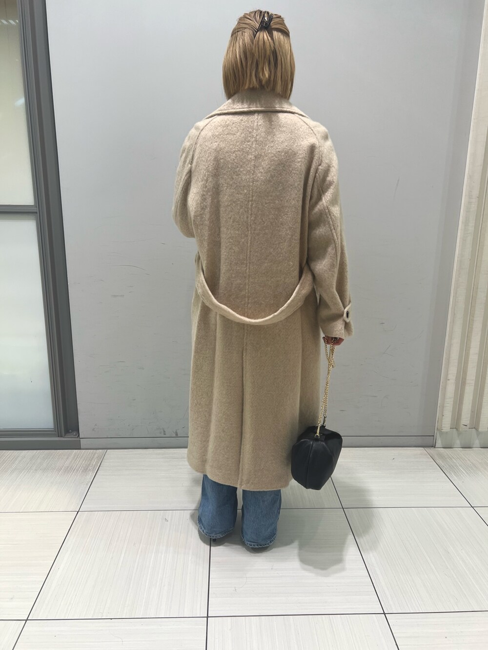 ブルー系のデニムパンツ、ブラウン系のワンピース、ベージュ系のその他アウターを着用したレディースの冬コーディネートの8枚目の写真