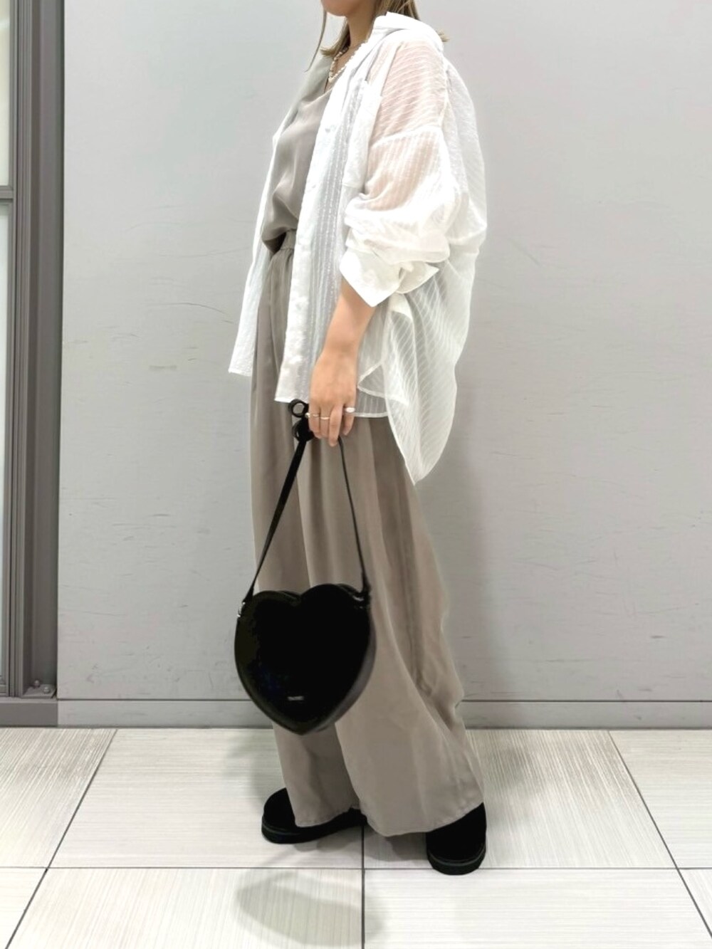 ブラック系のサンダル、ホワイト系のシャツ/ブラウス、ブラック系のショルダーバッグを着用したレディースの夏コーディネートの9枚目の写真