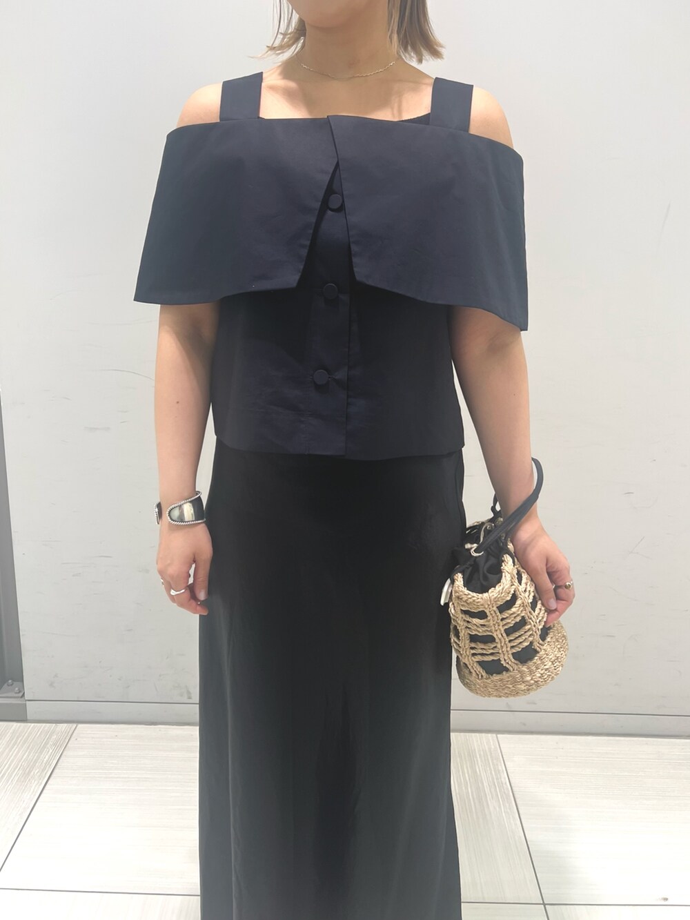 ベージュ系のかごバッグ、ブラック系のシャツ/ブラウス、ブラック系のスカートを着用したレディースの春コーディネートの6枚目の写真