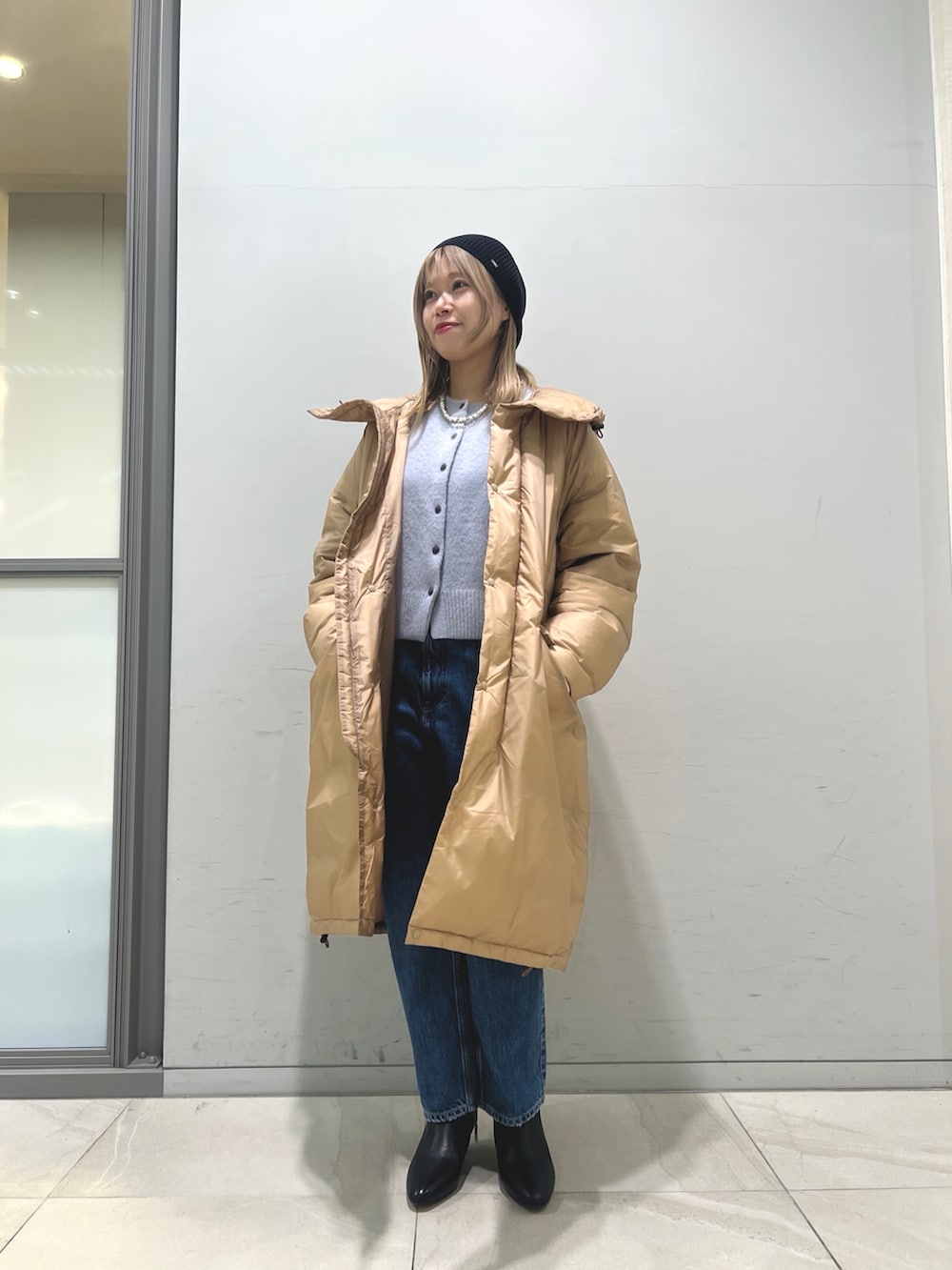 ブラウン系のダウンジャケット/コート、ブルー系のカーディガン/ボレロ、ブルー系のデニムパンツを着用したレディースの冬コーディネートの6枚目の写真