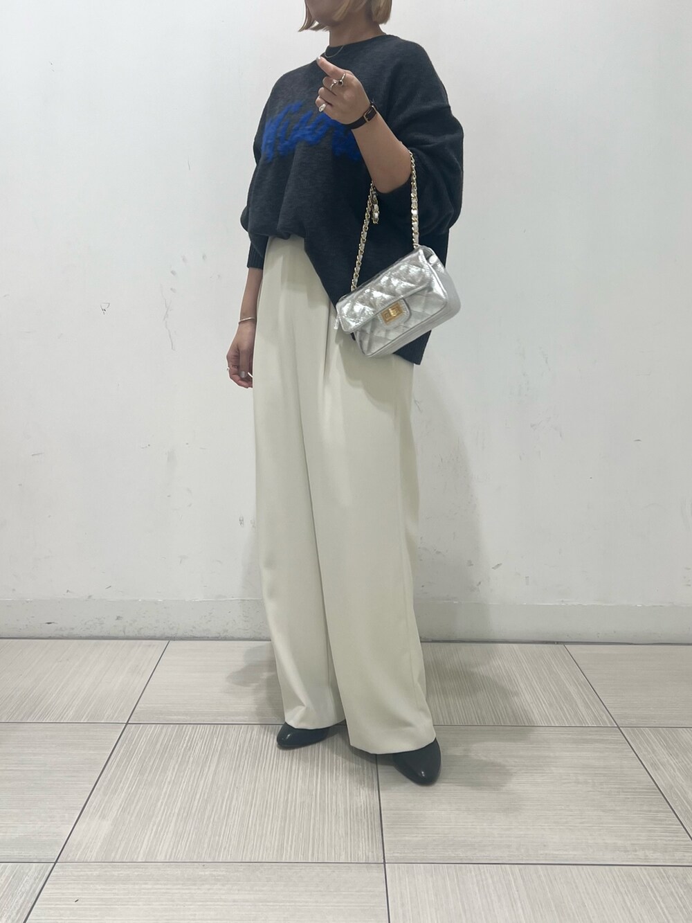 グレー系のニット/セーター、ホワイト系のその他パンツ、ブラック系のブーツを着用したレディースの秋コーディネートの3枚目の写真