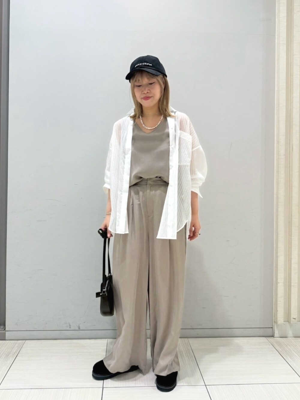 ブラック系のサンダル、ホワイト系のシャツ/ブラウス、ブラック系のショルダーバッグを着用したレディースの夏コーディネートの4枚目の写真