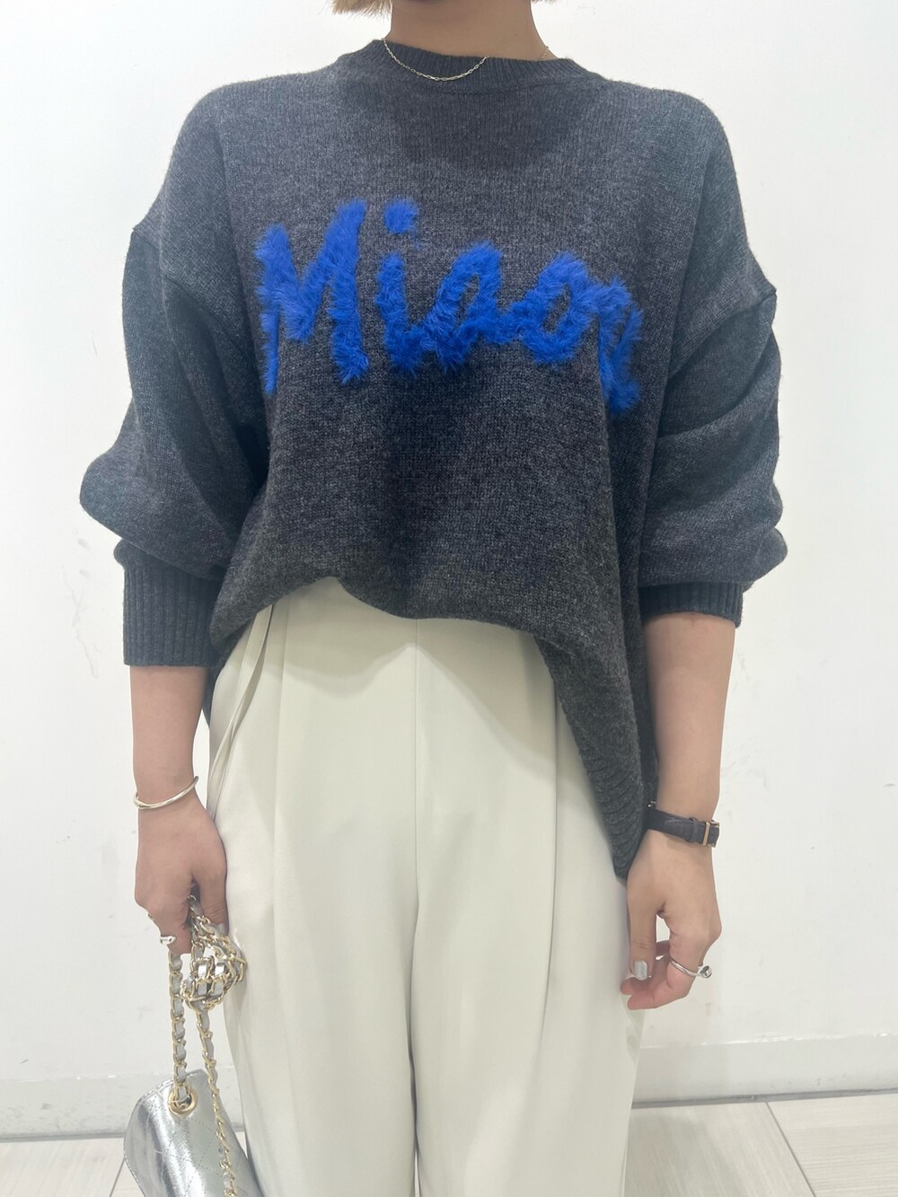 グレー系のニット/セーター、ホワイト系のその他パンツ、ブラック系のブーツを着用したレディースの秋コーディネートの4枚目の写真