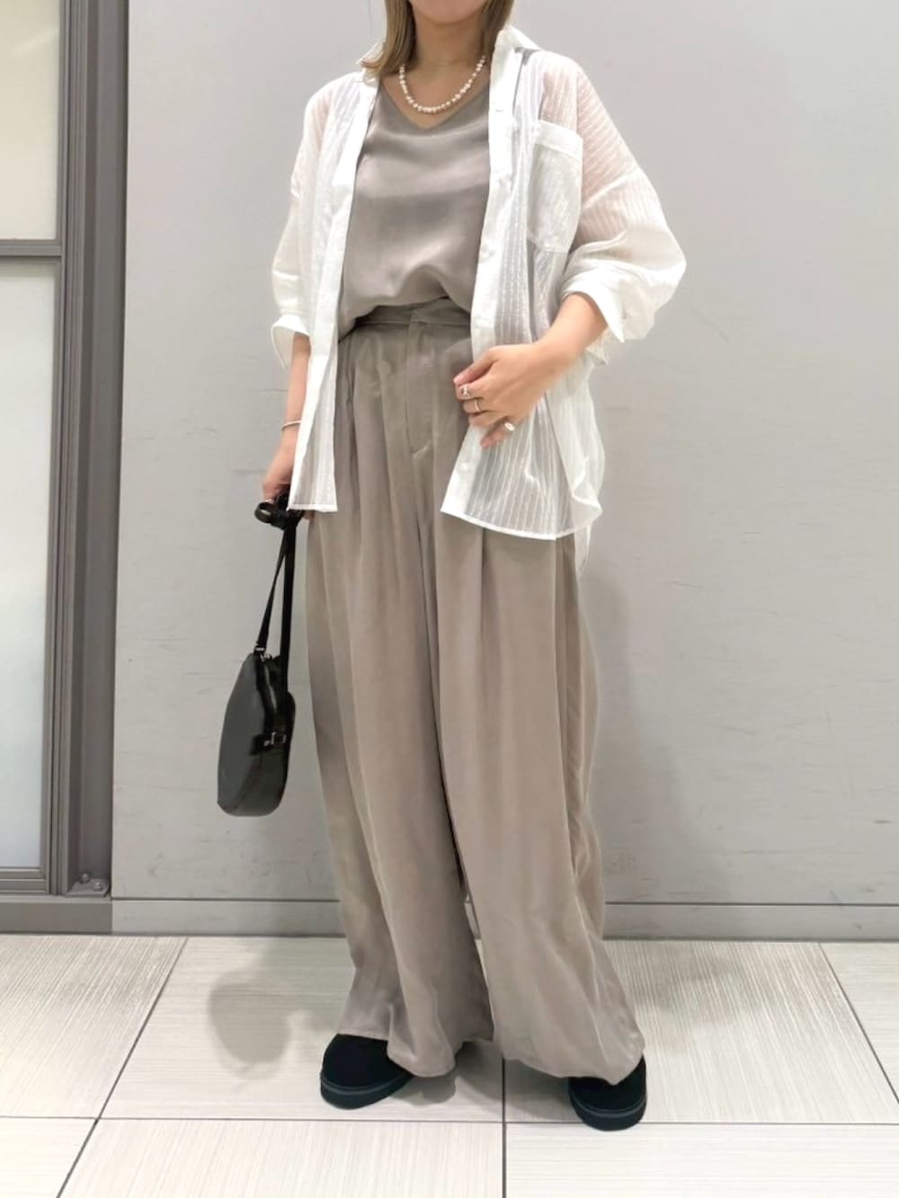 ブラック系のサンダル、ホワイト系のシャツ/ブラウス、ブラック系のショルダーバッグを着用したレディースの夏コーディネートの10枚目の写真