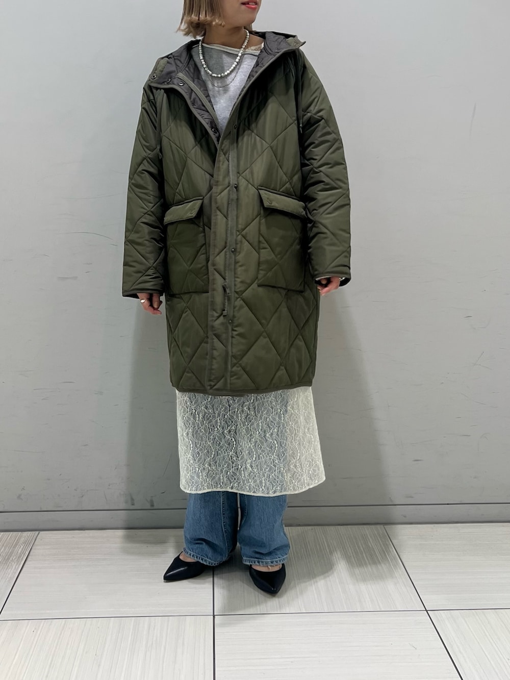 ホワイト系のワンピース、グレー系のTシャツ/カットソー、ブルー系のデニムパンツを着用したレディースの冬コーディネートの4枚目の写真