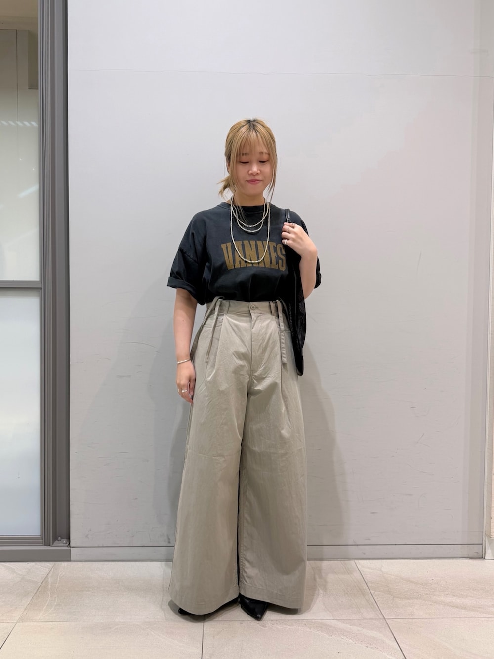ベージュ系のその他パンツ、ブラック系のTシャツ/カットソー、ブラック系のトートバッグを着用したレディースの春コーディネートの2枚目の写真