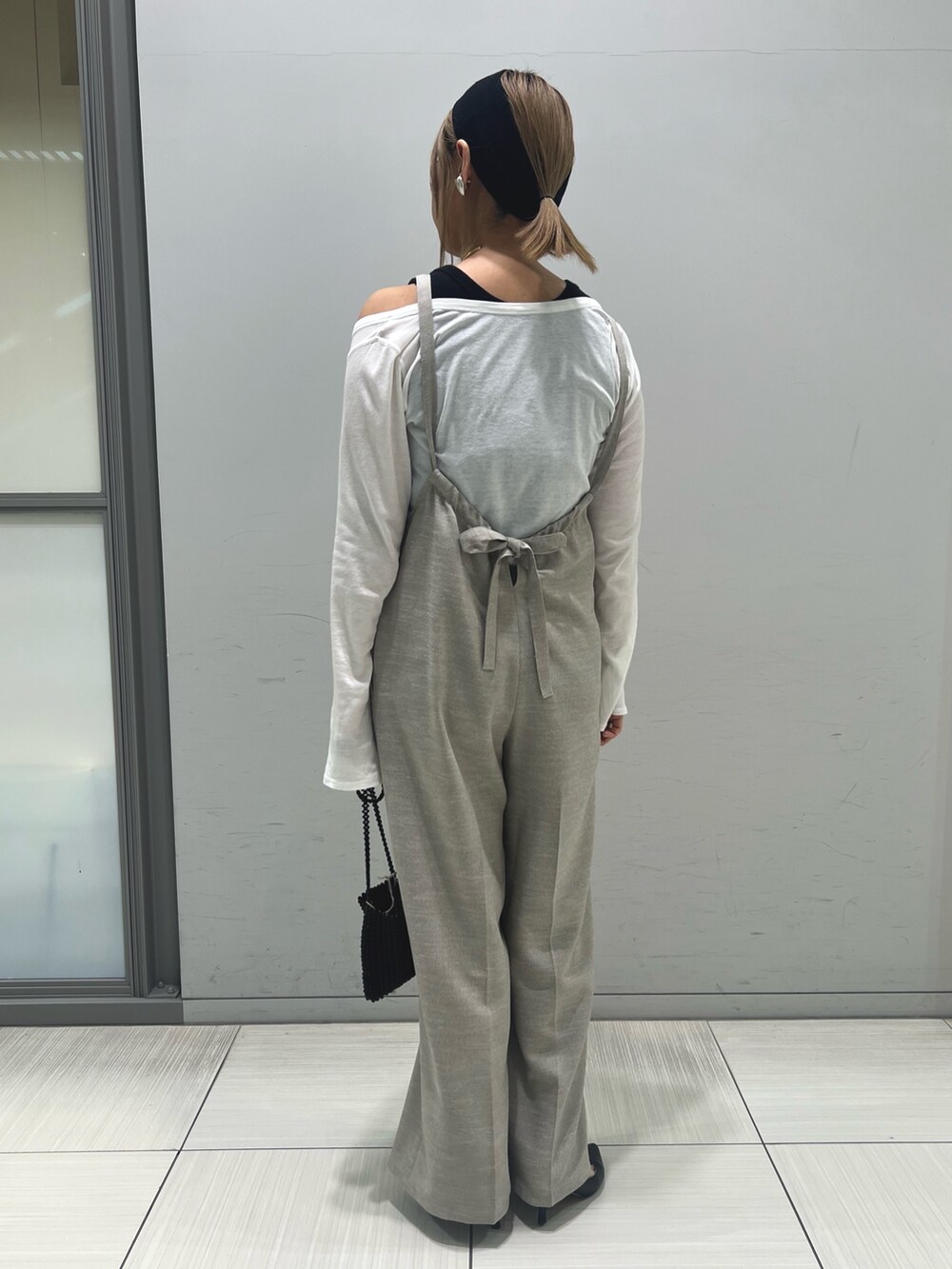 ホワイト系のTシャツ/カットソー、ベージュ系のサロペット/オーバーオール、ブラック系のタンクトップを着用したレディースの春コーディネートの5枚目の写真