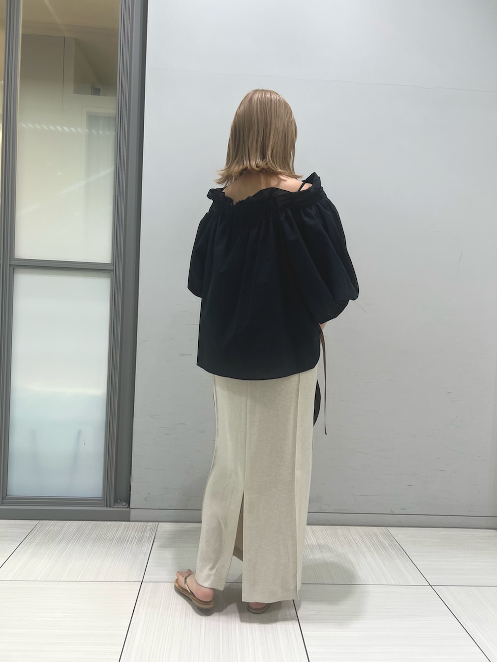 ベージュ系のかごバッグ、ゴールド系のサンダル、ブラック系のシャツ/ブラウスを着用したレディースの春コーディネートの4枚目の写真