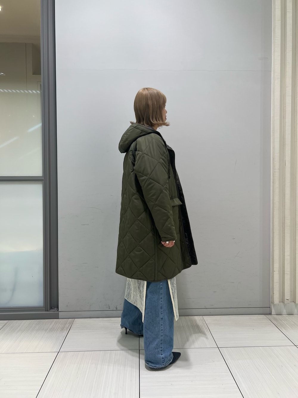 ホワイト系のワンピース、グレー系のTシャツ/カットソー、ブルー系のデニムパンツを着用したレディースの冬コーディネートの5枚目の写真