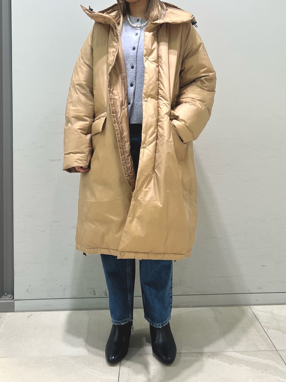 ブラウン系のダウンジャケット/コート、ブルー系のカーディガン/ボレロ、ブルー系のデニムパンツを着用したレディースの冬コーディネートの5枚目の写真