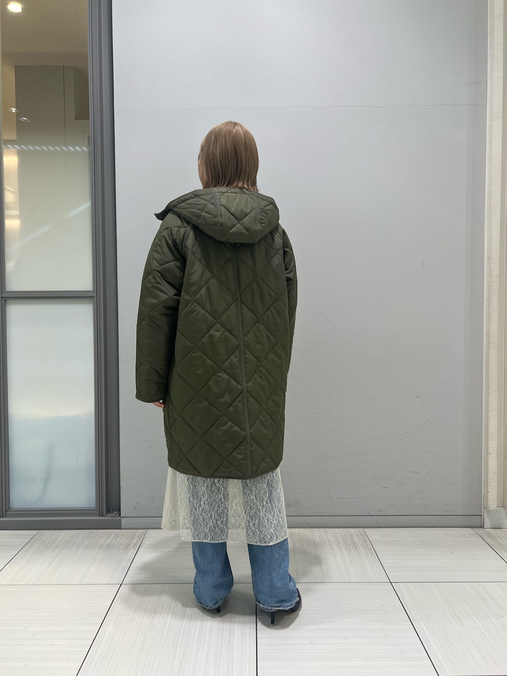 ホワイト系のワンピース、グレー系のTシャツ/カットソー、ブルー系のデニムパンツを着用したレディースの冬コーディネートの6枚目の写真