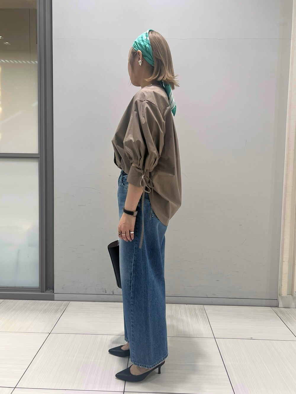 ブラウン系のシャツ/ブラウス、ブルー系のデニムパンツ、ブラック系のハンドバッグを着用したレディースの春コーディネートの5枚目の写真