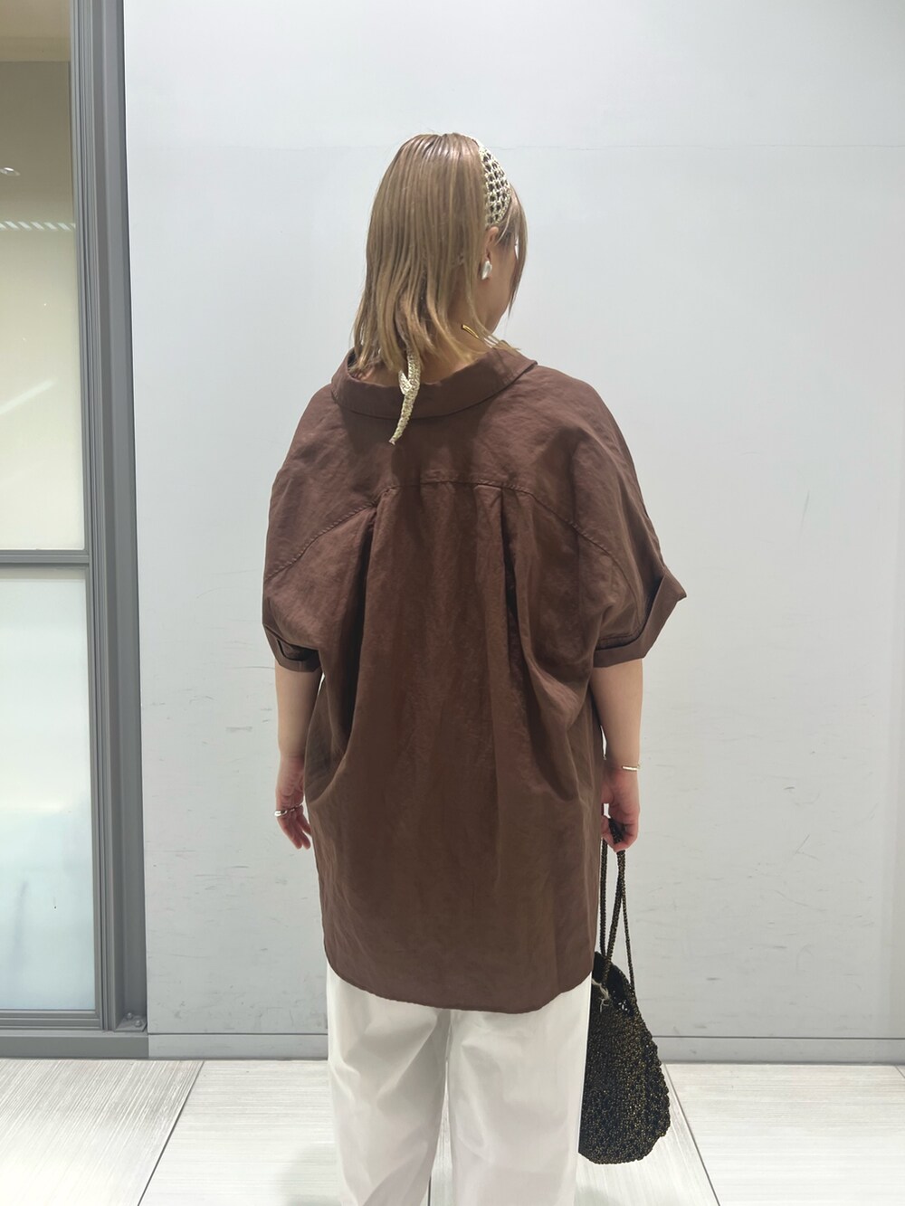 ブラック系のタンクトップ、ホワイト系のその他パンツ、ブラック系のショルダーバッグを着用したレディースの夏コーディネートの4枚目の写真