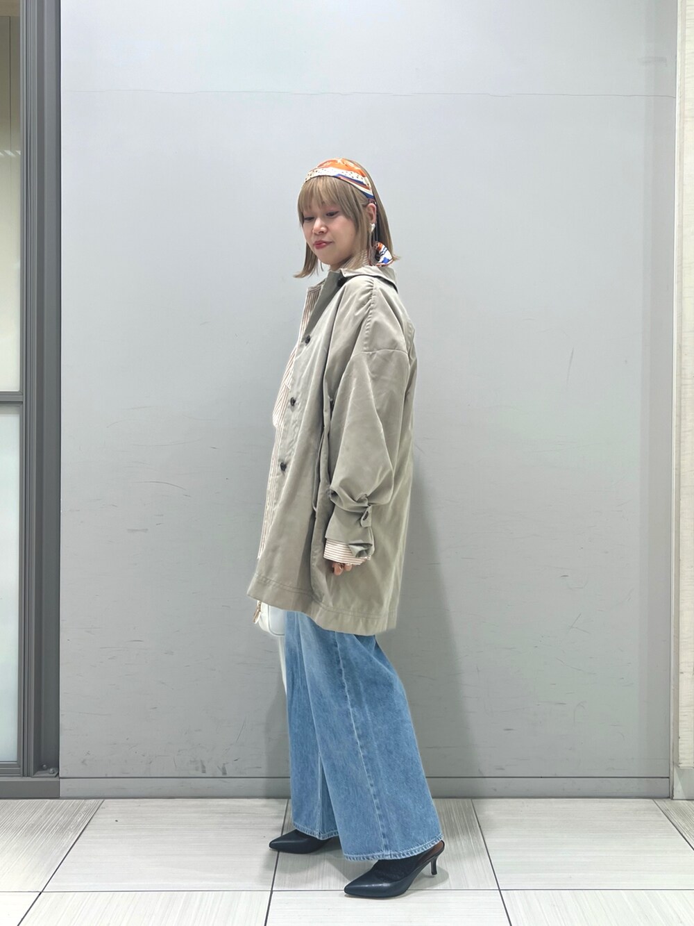 ブルー系のデニムパンツ、ホワイト系のショルダーバッグ、ベージュ系のシャツ/ブラウスを着用したレディースの冬コーディネートの4枚目の写真