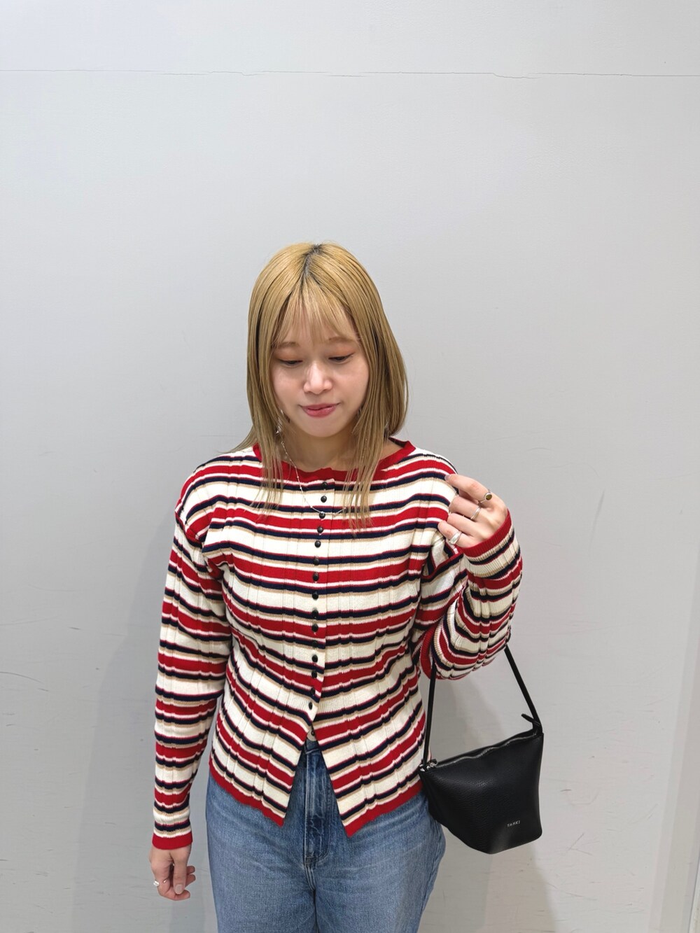 その他のニット/セーター、ブルー系のデニムパンツ、ブラック系のショルダーバッグを着用したレディースの冬コーディネートの2枚目の写真