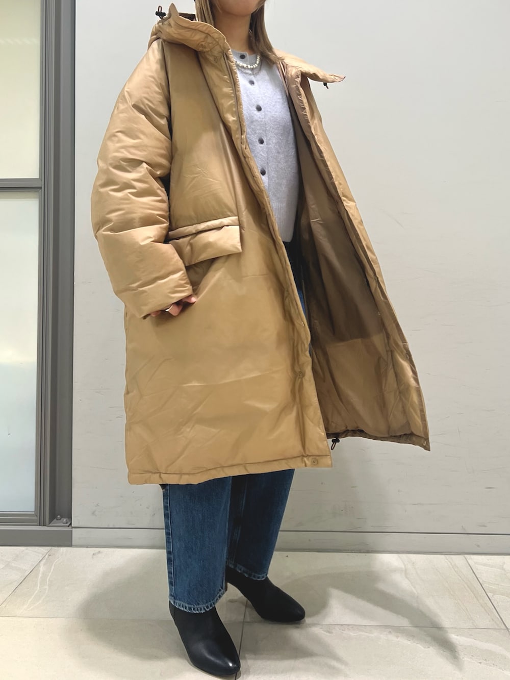 ブラウン系のダウンジャケット/コート、ブルー系のカーディガン/ボレロ、ブルー系のデニムパンツを着用したレディースの冬コーディネートの2枚目の写真