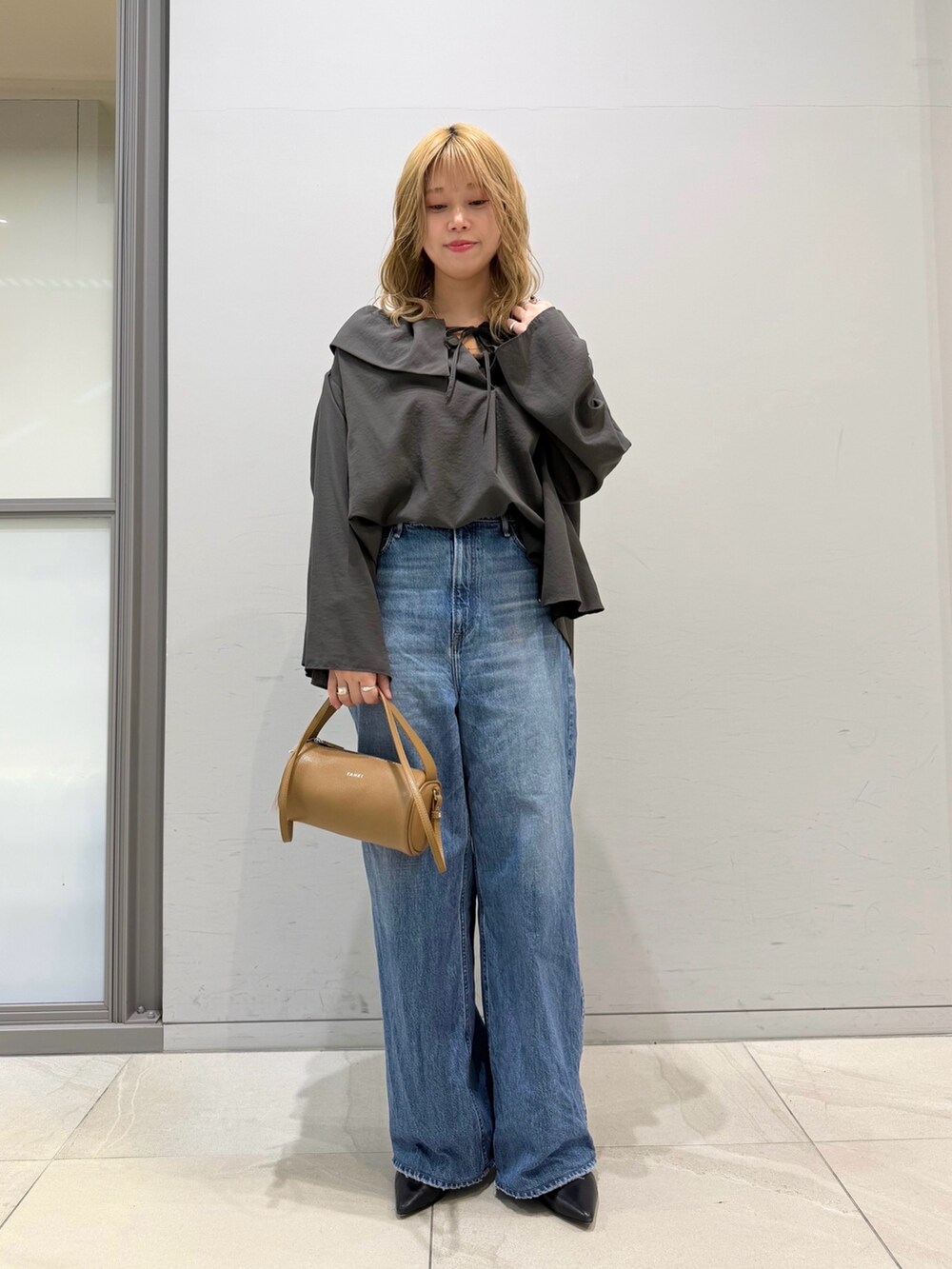 ブルー系のデニムパンツ、オレンジ系のショルダーバッグ、グレー系のシャツ/ブラウスを着用したレディースの春コーディネートの6枚目の写真