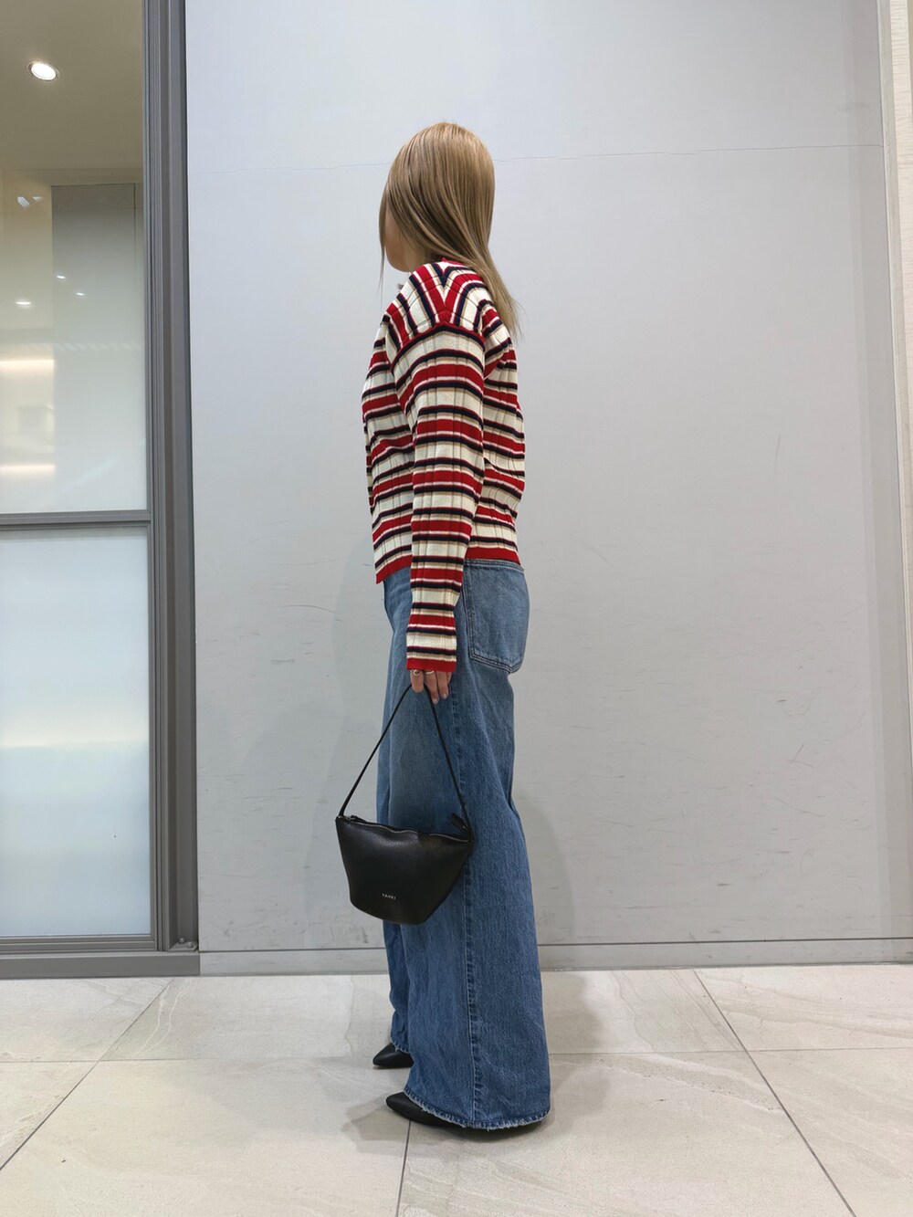 その他のニット/セーター、ブルー系のデニムパンツ、ブラック系のショルダーバッグを着用したレディースの冬コーディネートの5枚目の写真