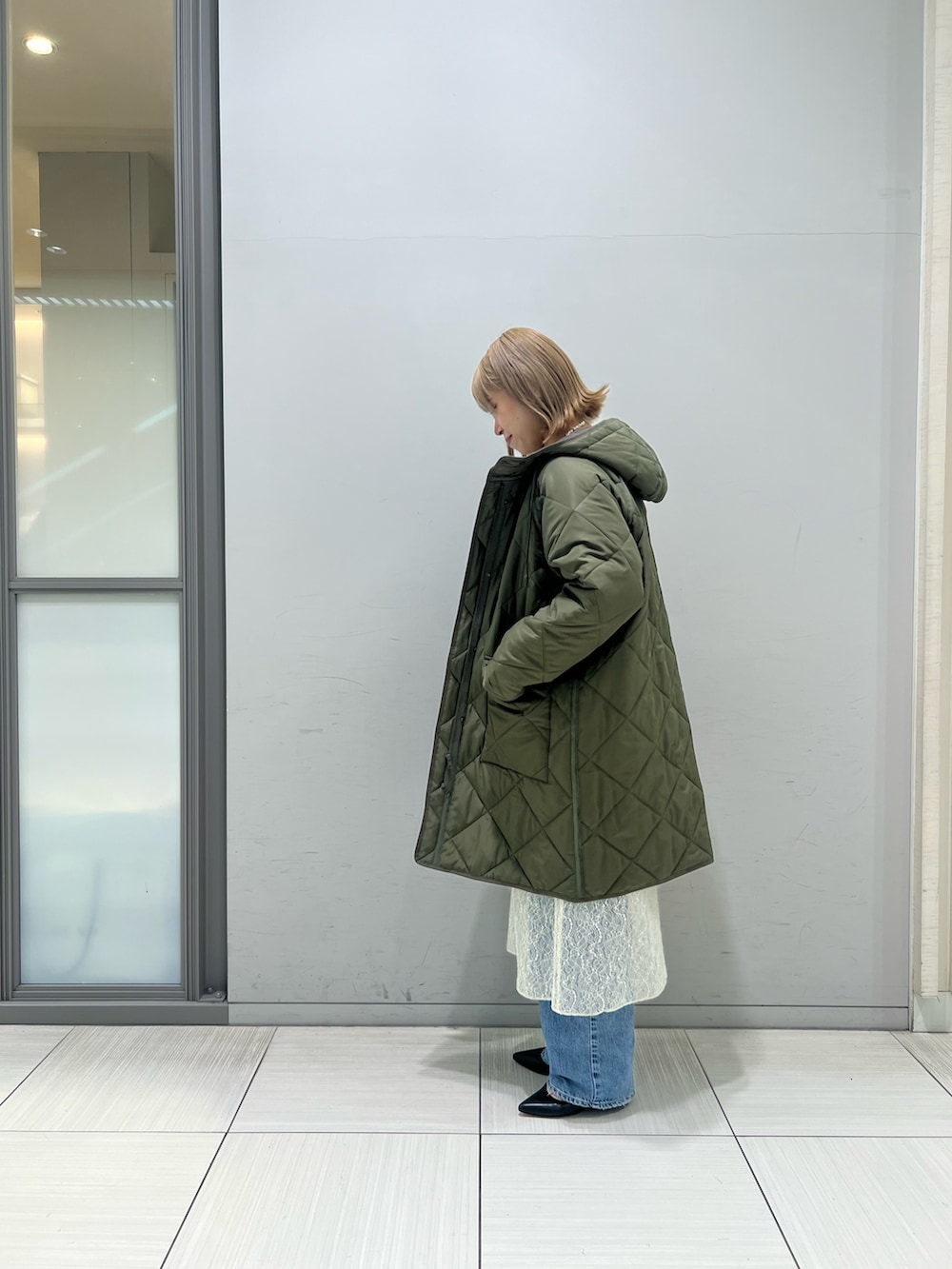 ホワイト系のワンピース、グレー系のTシャツ/カットソー、ブルー系のデニムパンツを着用したレディースの冬コーディネートの8枚目の写真