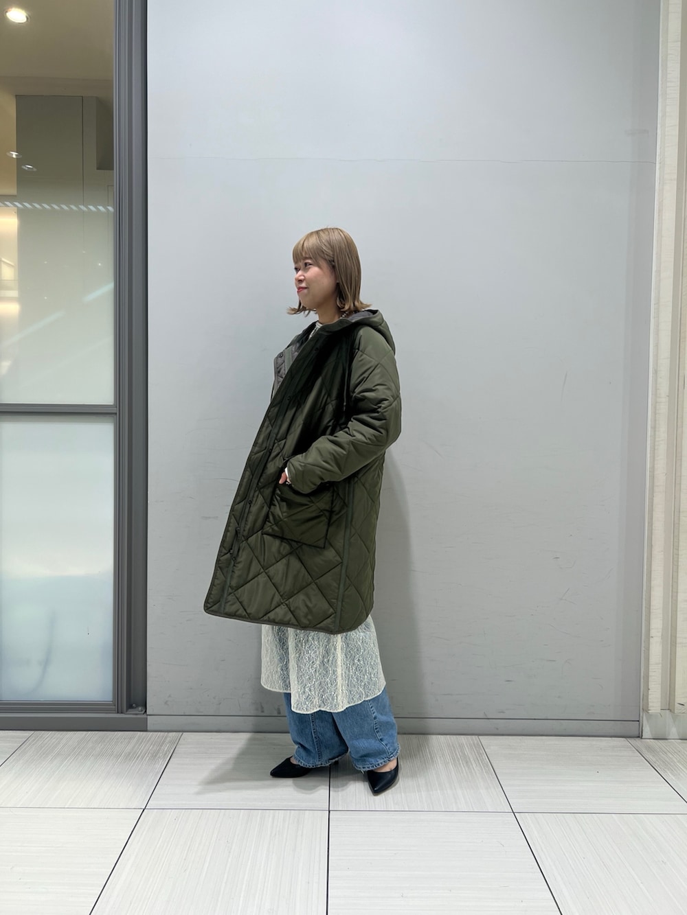 ホワイト系のワンピース、グレー系のTシャツ/カットソー、ブルー系のデニムパンツを着用したレディースの冬コーディネートの2枚目の写真